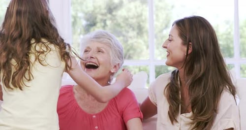 Family Hugging Together on Sofa Indoors