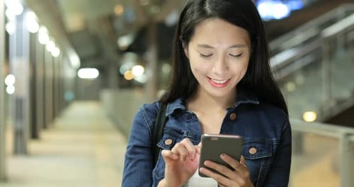 Woman Using Smartphone in Urban Underground Walkway