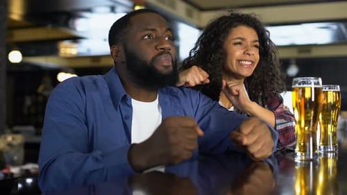 Young Man and Woman Feeling Disappointed by Game Result, Fans Rooting in Bar
