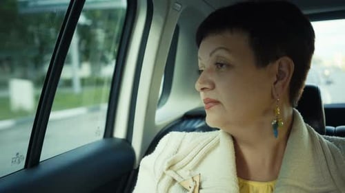 Woman Riding in Car Through City During Sunny Day