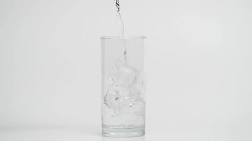 Movimiento superlento de verter agua en un vaso con hielo a 1000 fps