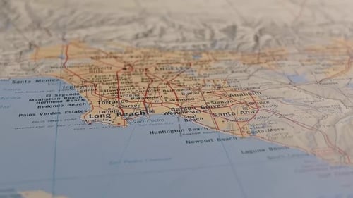 Slider Shot mit geringer Schärfentiefe zur Enthüllung der US-Stadt Los Angeles auf einer gedruckten Karte