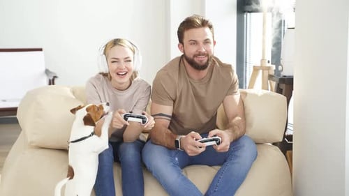Couple Playing Video Games with Dog at Home