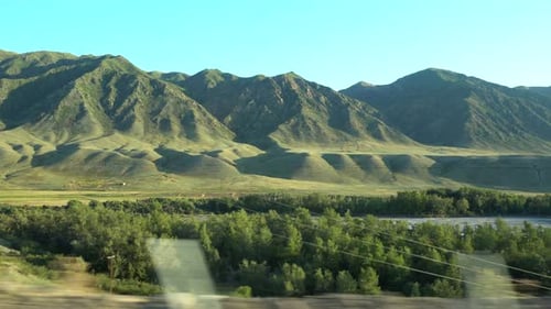 View of the green hills, trees from the car window. Travel to Kazakhstan.