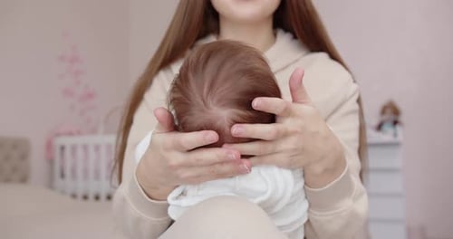 Loving Mother Comforts Newborn Baby at Home