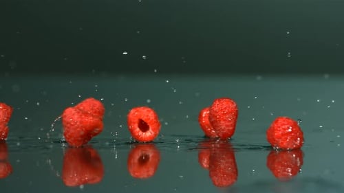 Raspberries Falling and Splashing on Reflective Surface