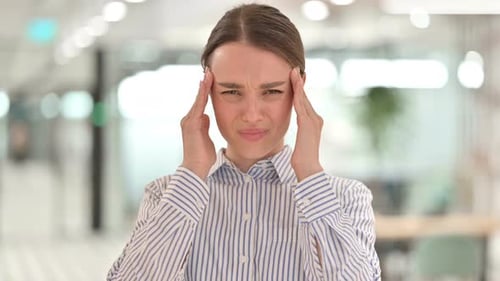 Young Woman Experiencing Headache at the Office