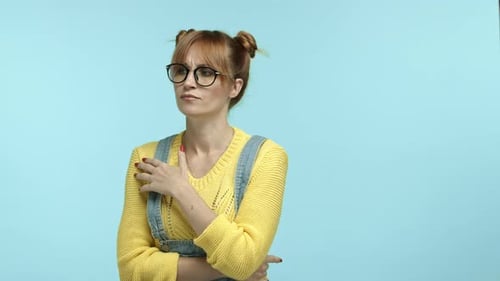 Nerdiges süßes Mädchen mit Brille, das nachdenklich steht und wegschaut und an etwas denkt, das nach Luft schnappt und