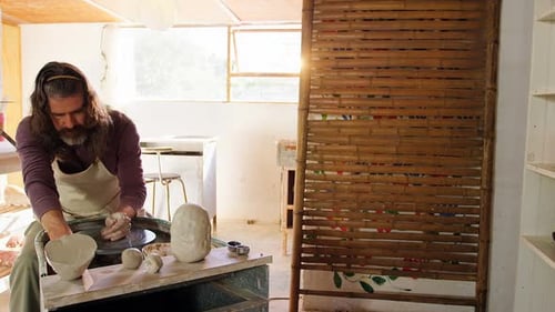 Potter Shaping Clay on Wheel in Bright Studio