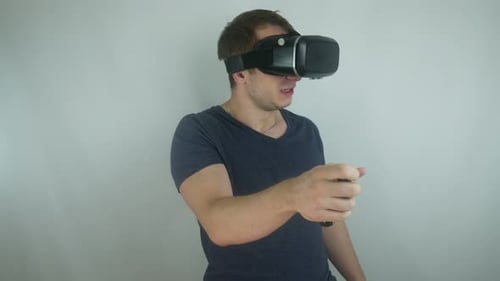 Young Man Uses A Virtual Reality Helmet In A Simulation Game