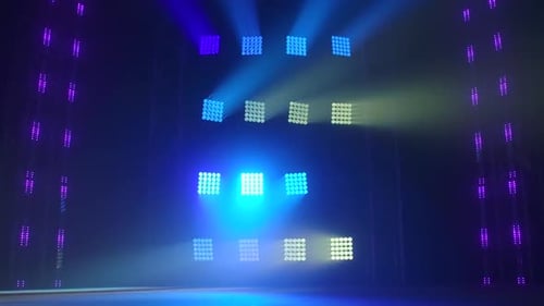 Die Bühne eines kleinen Theaters mit roten und blauen Scheinwerfern. Lichter werden aus der Dunkelheit eingeschaltet.