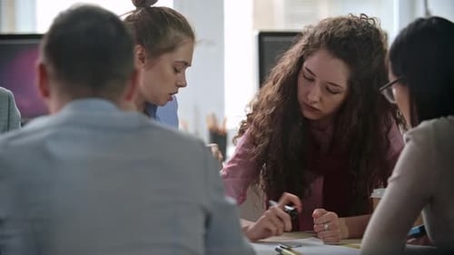 Professionals Collaborating at Table in Office Workplace