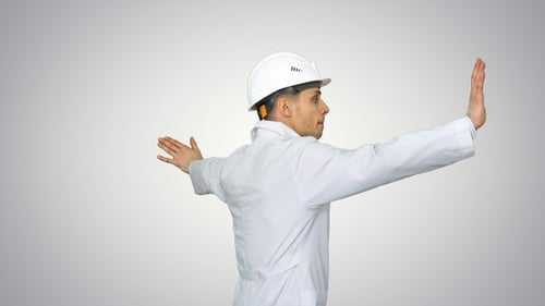 Un jeune ouvrier avec un casque en robe blanche aime danser
