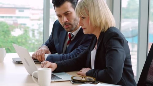 Two Business People Talk Project Strategy at Office