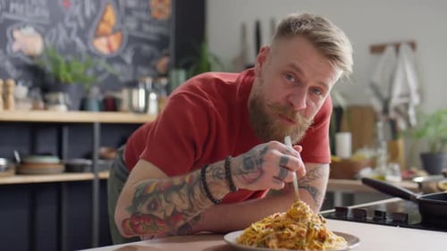 Man Enjoys Spaghetti Lunch in Kitchen Setting