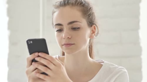 Young Woman Using Smartphone in Office