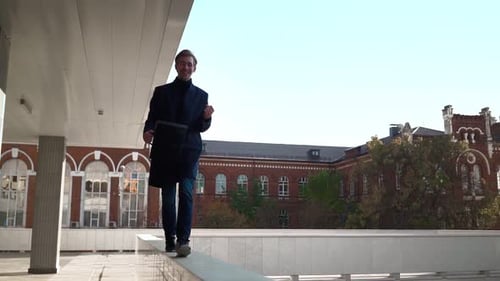 Man Walking and Jumping off a Building's Ledge