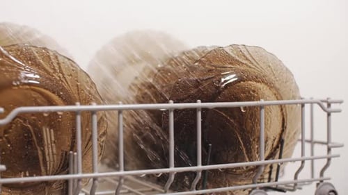 Dishwasher Washes Plates by Stream of Clean Water on White Background