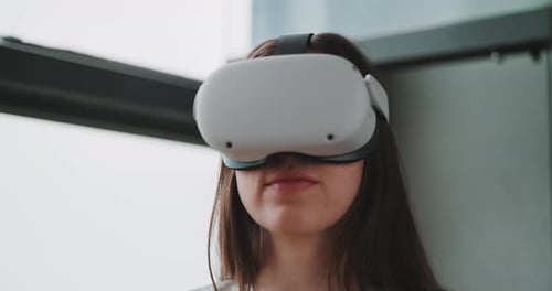 Close up of young woman wearing vr goggles with her hands in the foreground