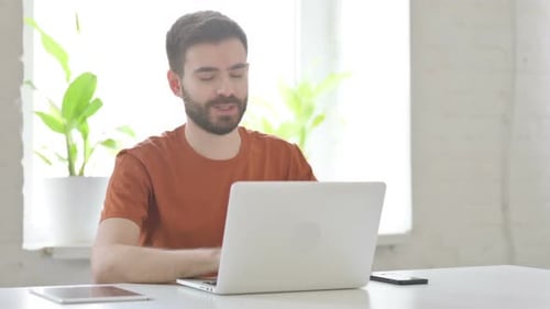 Young Adult Video Call at Desk Using Laptop