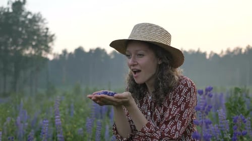 Woman in Field Blowing Flower Petals