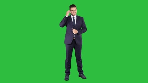 Professional Man with Headset Adjusting Microphone on Greenscreen