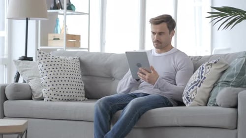 Man Relaxing on Couch with Tablet Indoors