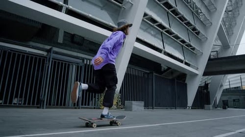 Young Skateboarder Practicing in City Stadium
