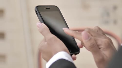 Hands Using a Smartphone to Scroll on Screen