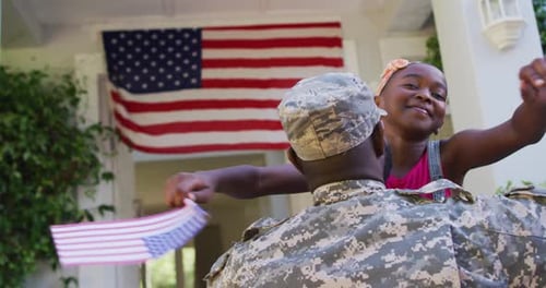 Child Hugs Soldier in Front of American Flag