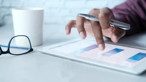 Man's Hand Working on Digital Tablet at Office Desk, Using Self Created Chart