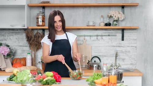 Woman Prepares a Salad in a Kitchen