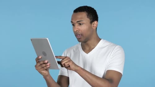 Frustrated Man Complaining While Using Tablet Indoors
