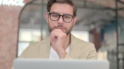 Close Up of Man Thinking While Working on Laptop