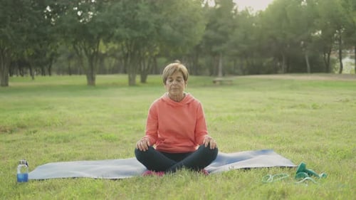 Senior Woman Doing Yoga Meditation Routine Outdoor at City Park Elderly Healthy Lifestyle
