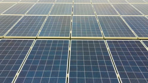 Closeup of surface of blue photovoltaic solar panels mounted on building roof for producing
