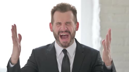 Angry Man Shouts in Frustration Indoors