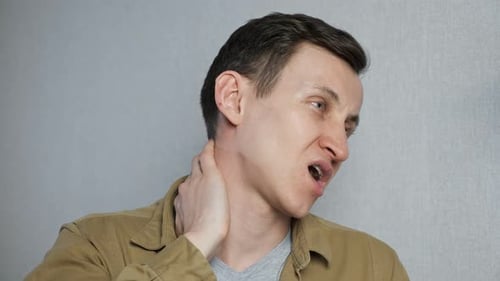 Man Rubbing Neck in Painful Discomfort