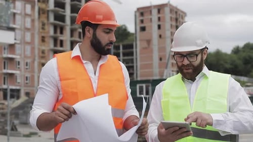 Building a Residential Complex or Business Center. Team of Engineers Men with a Tablet and Drawing