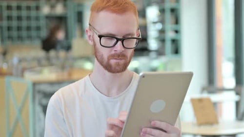 Young Man Using Tablet Device Indoors