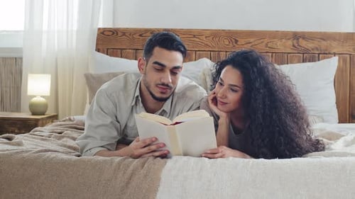 Couple Reading a Book Together on Bed