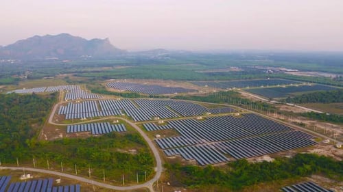 Aerial view of solar panels or solar cells on the roof in farm. Power plant with green field