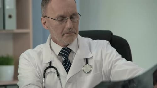 Doctor Reviews X-ray Images in Office Setting