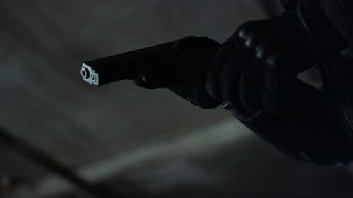 Killer in Gloves Loading Gun Clip