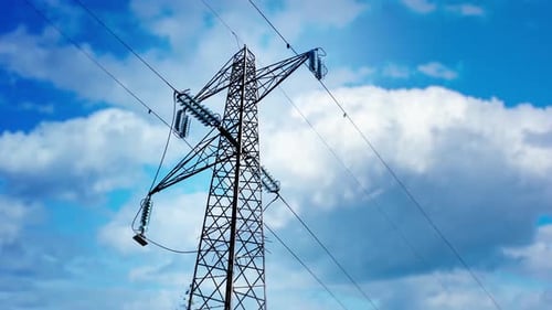 Electrical Tower Against Bright Cloudy Sky