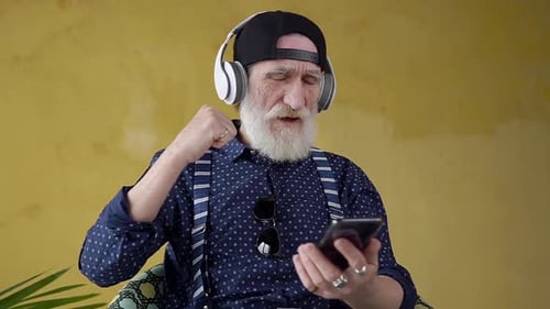 Senior Man Listens and Dances with Headphones