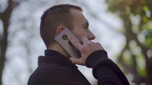 Young Man Talking on Phone in Urban Setting