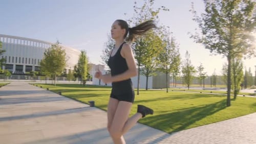 Sports Woman Makes Morning Jog and Physical Exercises In Park