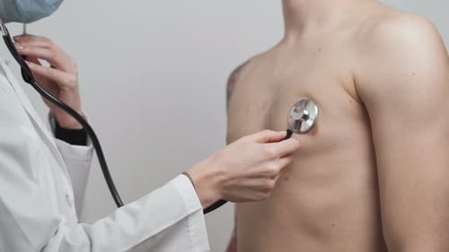 Doctor Examining Male Patient Chest with Stethoscope in Clinic. Coronavirus Tests at the Hospital