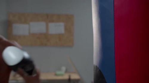 Boxer Punches a Punching Bag in the Gym